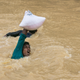 A man struggling to cross a stream during the monsoon season in Bangladesh in September 2017. Photo: Getty